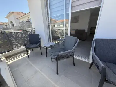 a patio with three chairs and a table on a balcony at Mythical Sands 2 - F in Paralimni