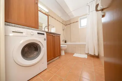 a washing machine in a bathroom with a toilet at 2 bedroom flat in Strovolos