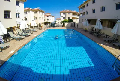 a large blue swimming pool next to some buildings at Thea Court 3 - E in Paralimni