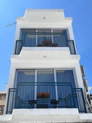 a white building with a balcony with two chairs at Unique 2 storey apt city centre in Larnaka