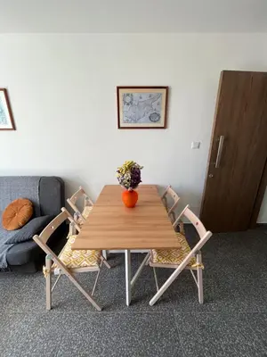 a wooden table with two chairs and a vase of flowers on it at Unique 2 storey apt city centre in Larnaka