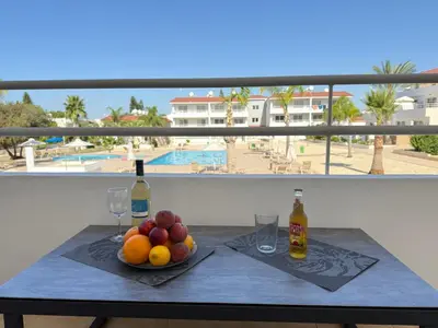 a table with fruit and wine glasses on a balcony at Nissi 3, 1 -B in Ayia Napa