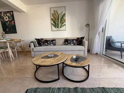 a living room with two tables in front of a couch at Nissi 3, 1 -B in Ayia Napa