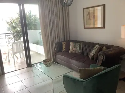 a living room with a couch and a glass table at Urban Nest - near GSP & General Hospital in Laxia