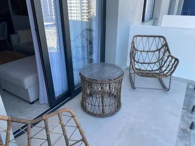 a wicker chair and a chair on a balcony at Sunrise 80 in Aglantzia