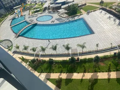 an overhead view of two swimming pools with palm trees at Sunrise 80 in Aglantzia