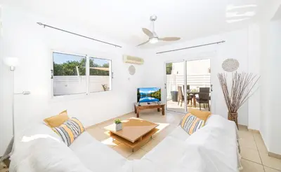 a living room with a white couch and a table at Ayia Triada Beach Gardens in Protaras