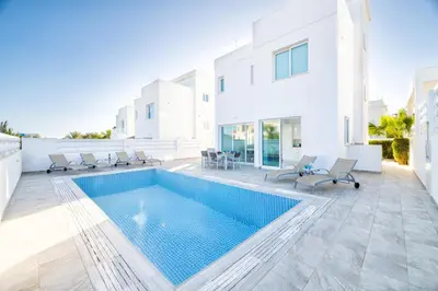 a swimming pool in the middle of a house at Green Bay Villa #12 in Protaras