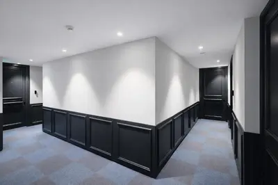 a hallway with black doors and a white wall at Sky Suites Nicosia in Strovolos