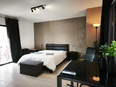 a bedroom with a bed and a table and a couch at 103 St Lazaros View Studio in Larnaka
