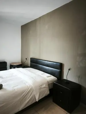 a bedroom with a large white bed with a black headboard at 103 St Lazaros View Studio in Larnaka