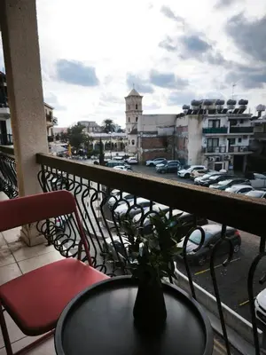 a balcony with a table and chairs and a view of a city at 103 St Lazaros View Studio in Larnaka