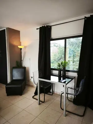 a living room with a table and a chair and a window at 103 St Lazaros View Studio in Larnaka