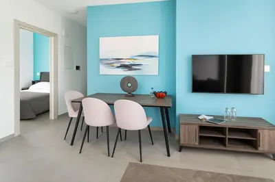 a dining room with a table and chairs and a tv at Modern 1BR with City View in Central Larnaca in Larnaka