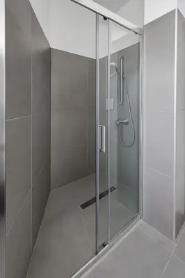 a shower with a glass door in a bathroom at Modern 1BR with City View in Central Larnaca in Larnaka