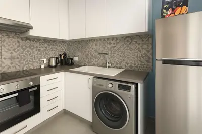 a kitchen with a washing machine and a sink at Modern 1BR with City View in Central Larnaca in Larnaka