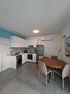 a kitchen and dining room with a wooden table and chairs at Luxury central 1BR with city view in Larnaka