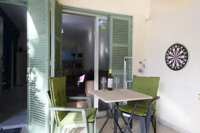 a dining room with a table and green chairs at Cozy flat by the sea with big pool tourist area in Limassol