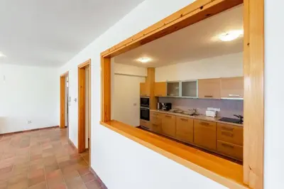 a kitchen with wooden cabinets and a large window at STAY Hillcrest Panorama Villa in Moniatis