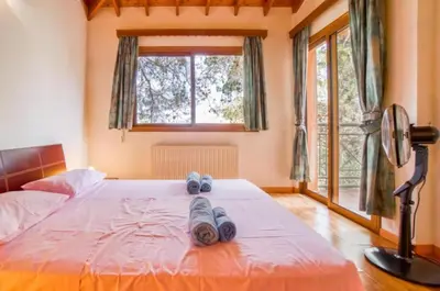 a bedroom with a bed with a fan and a window at STAY Hillcrest Panorama Villa in Moniatis