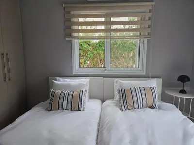 two beds with pillows in a bedroom with a window at Pop Art Residence by Staycom in Nicosia