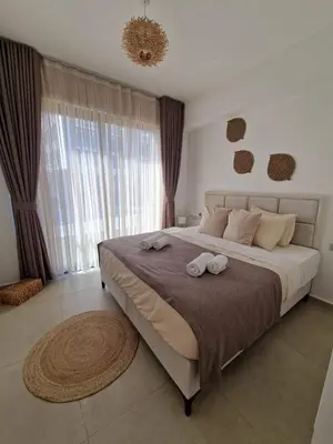 a bedroom with a large bed with two towels on it at Kantara Beach Resort Apartment Olivia in Aglantzia