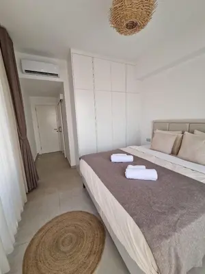 a bedroom with a bed with two towels on it at Kantara Beach Resort Apartment Olivia in Aglantzia