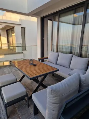 a living room with a couch and a table at Kantara Beach Resort Apartment Olivia in Aglantzia