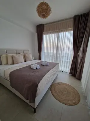 a bedroom with a large bed with two towels on it at Kantara Beach Resort Apartment Olivia in Aglantzia