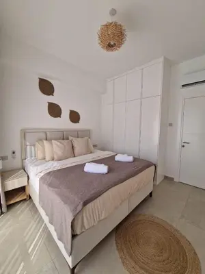 a bedroom with a large bed with two towels on it at Kantara Beach Resort Apartment Olivia in Aglantzia