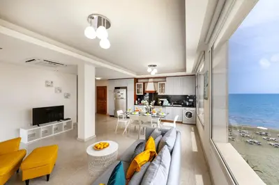 a living room with a couch and a view of the ocean at Mackenzie Beachfront Eftyhia Suite in Larnaka