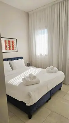 a bedroom with a large bed with two towels on it at 1BR Serviced Apt with Pool & Premium Amenities in Voroklini