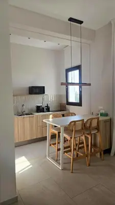 a kitchen with a white table and some chairs at 1BR Serviced Apt with Pool & Premium Amenities in Voroklini