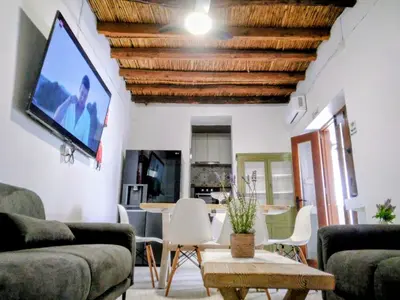 a living room with a couch and a tv on the wall at En chirokitia cottages in Chirokitia