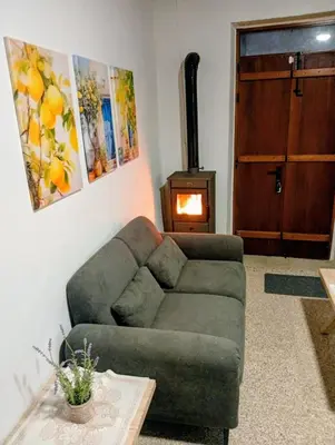 a living room with a couch and a wood stove at En chirokitia cottages in Chirokitia