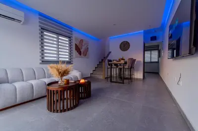 a living room with a couch and a table at TelMar White House - 100m from the Sea in Voroklini