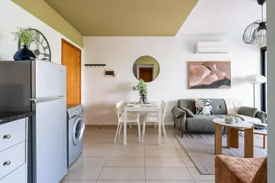 a kitchen and living room with a couch and a table at Odin 1-BR Apartment & Balcony in Larnaca in Larnaka
