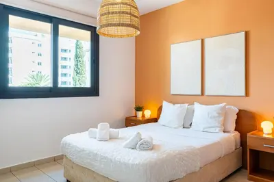 a bedroom with a large bed with two windows at Odin 1-BR Apartment & Balcony in Larnaca in Larnaka