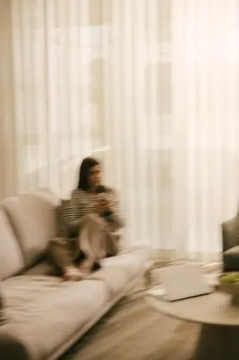 a woman sitting on a couch in a living room at Pinewood by Holistays in Engomi