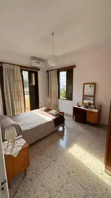 a bedroom with a large bed and a mirror at Coast & City Apartment in Limassol
