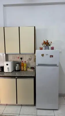 a kitchen with white cabinets and a white refrigerator at Coast & City Apartment in Limassol
