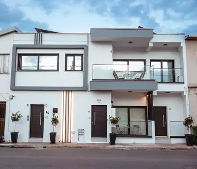 a white house with black doors and windows at K-Apartments Managed by Quattro Forze Group in Larnaka