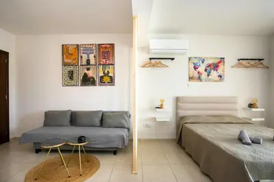 a bedroom with a bed and a couch at Modern & Fancy ground floor Studio - Pool & Relax in Tersephanou