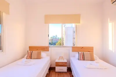 two beds in a small room with a window at TelMar Port Sea View - 10 minutes walk from Finikoudes in Larnaka