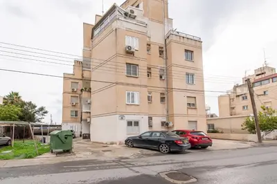 a building with two cars parked in front of it at TelMar Port Sea View - 10 minutes walk from Finikoudes in Larnaka