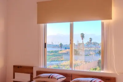 a bedroom with a window with a view of the water at TelMar Port Sea View - 10 minutes walk from Finikoudes in Larnaka