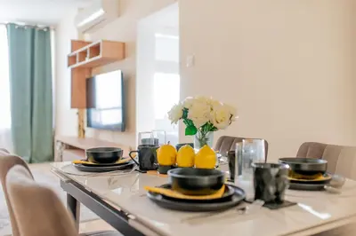 a dining room table with lemons and a vase of flowers at TelMar Port Sea View - 10 minutes walk from Finikoudes in Larnaka