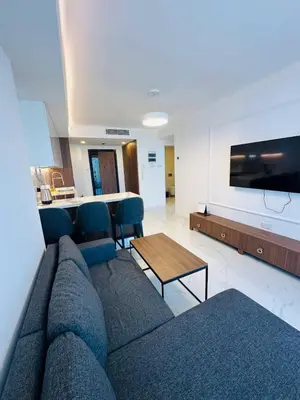 a living room with a blue couch and a table at Grand Sapphire Casino, High Floor, Sea View in Lythrodontas
