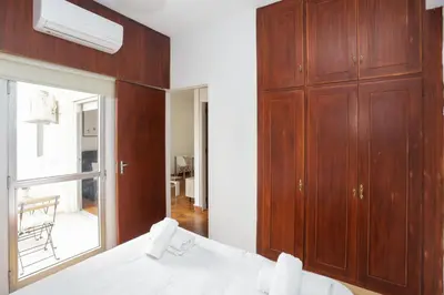 a bedroom with wooden cabinets and a bed with a mirror at Palmove Makenzy Charming 1Bed Apt in Larnaka