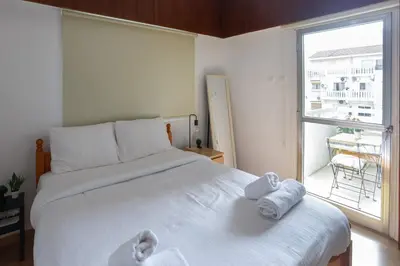 a bedroom with a large white bed with towels on it at Palmove Makenzy Charming 1Bed Apt in Larnaka